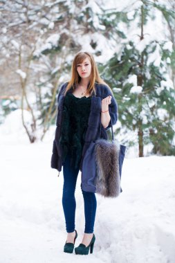 Tam uzunlukta kürk giyen genç güzel zarif esmer kadın portresi. Moda kız kış street yürüyüş.