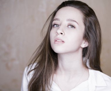 Stüdyo duvar arka plan üzerinde beyaz gömlekli genç güzel bir esmer kadın