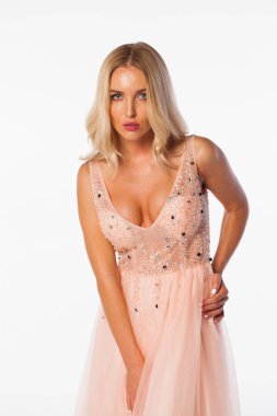 Beyaz izole arka plan üzerinde poz pembe elbiseli sarışın çok seksi genç kadın moda portre 