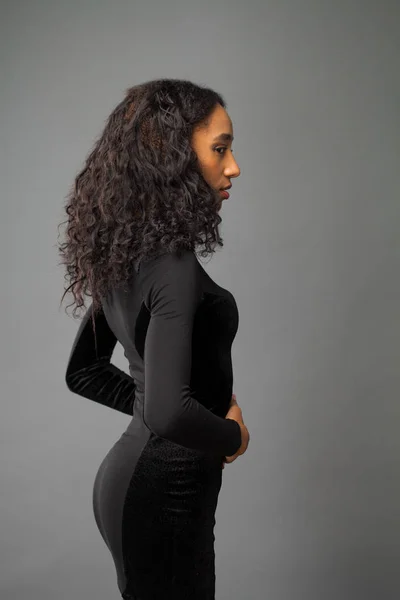 非洲黑发妇女炫耀她的长卷发 隔离在灰色的背景 — 图库照片