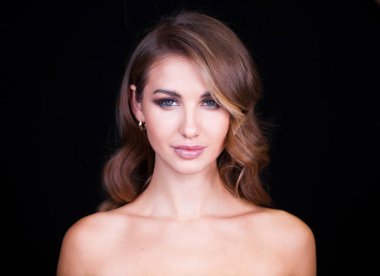 Siyah arka planda uzun sarı saçlı güzel bir mankenin yakın plan portresi.