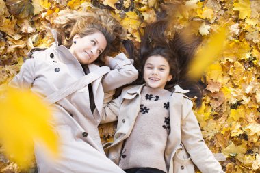 Genç Anne ve kızı sonbahar parkta yürüyüş