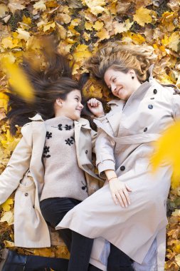 Genç Anne ve kızı sonbahar parkta yürüyüş