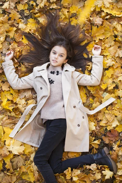 Schönes Kleines Mädchen Legt Sich Einem Schönen Herbsttag Auf Blätter — Stockfoto