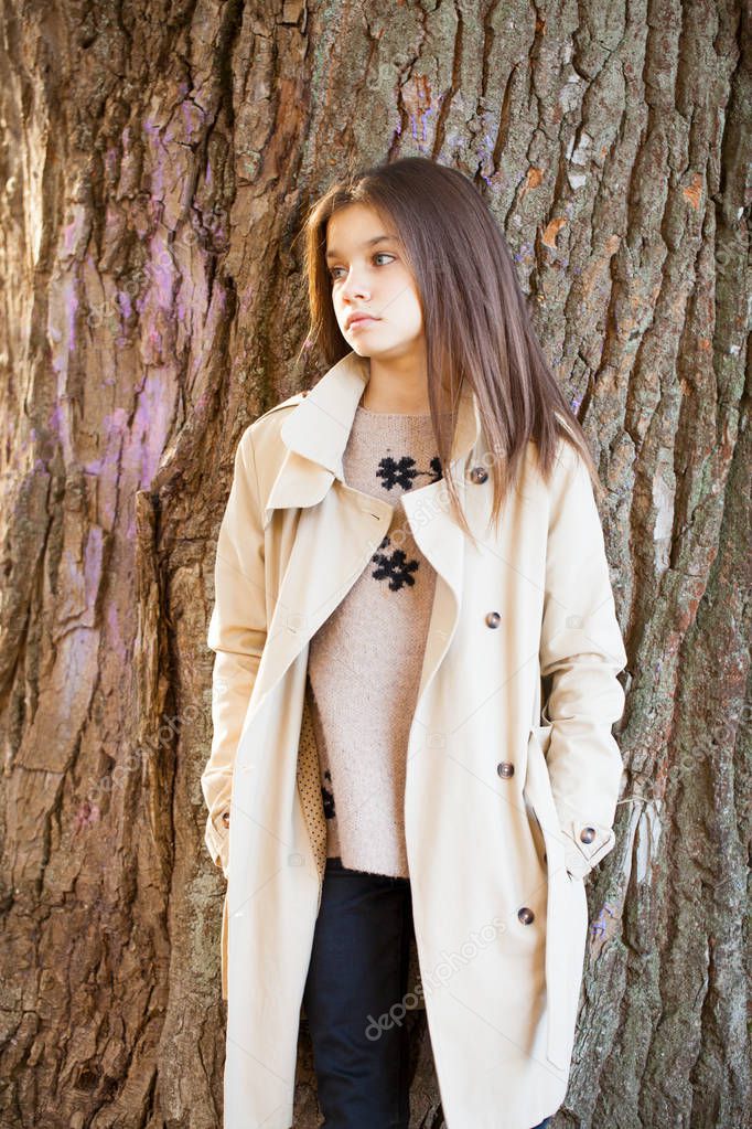 Portrait of a beautiful young brunette little girl, autumn park outdoors
