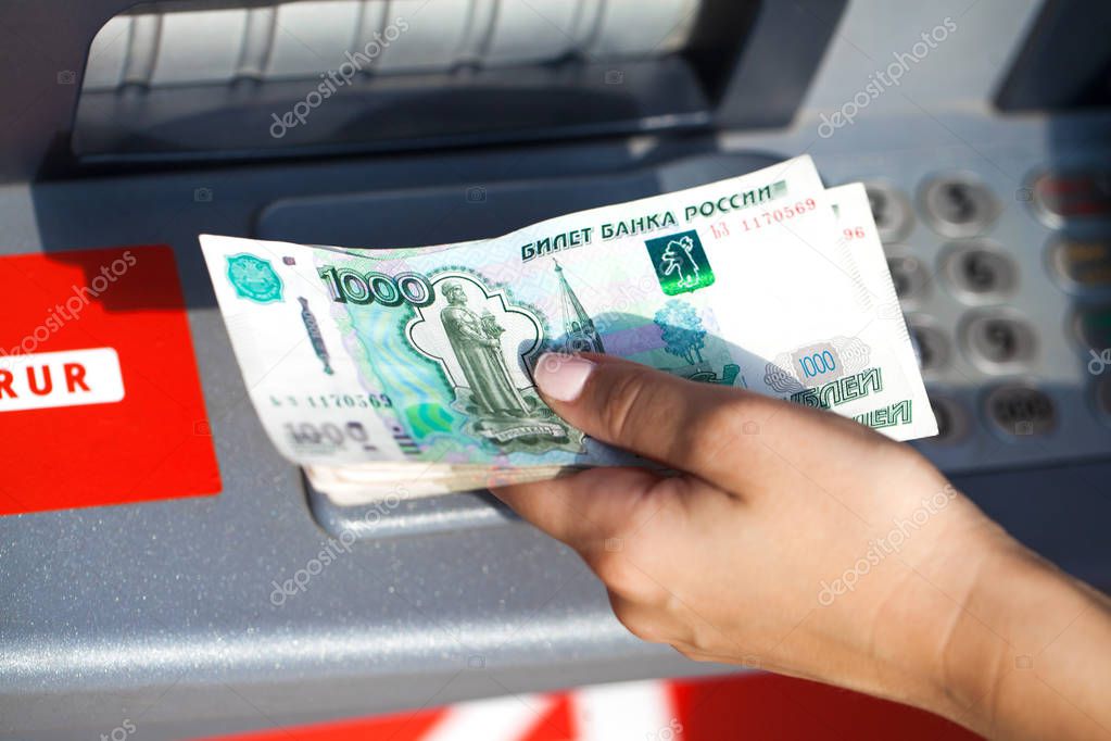 Russian rubles cash. Repayment on credit. Woman hand withdrawing money from outdoor bank ATM