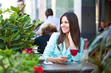 Zarif kız açık kafede kahve fincan ile dinlenme süre diyen birileri uzun siyah saçlı. Açık ciddi fashionista kadın fotoğrafı 