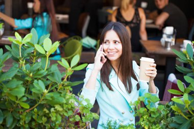 Zarif kız açık kafede kahve fincan ile dinlenme süre diyen birileri uzun siyah saçlı. Açık ciddi fashionista kadın fotoğrafı 
