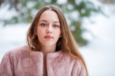 Kış park üzerinde poz kürk ceket genç güzel esmer kadın. Şık sıcak giysiler giyen modeli.