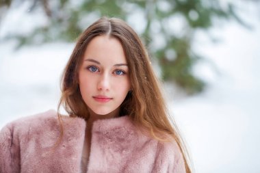 Kış park üzerinde poz kürk ceket genç güzel esmer kadın. Şık sıcak giysiler giyen modeli.