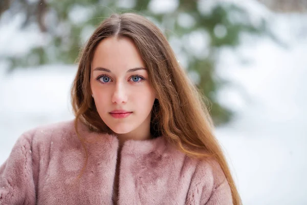 Kış park üzerinde poz kürk ceket genç güzel esmer kadın. Şık sıcak giysiler giyen modeli.