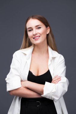 Mutlu sarışın model. İzole gri arka plan üzerinde beyaz gömlekli güzel genç kadın portresi