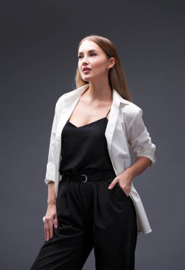 Mutlu sarışın model. İzole gri arka plan üzerinde beyaz gömlekli güzel genç kadın portresi