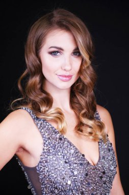 Siyah arka planda uzun sarı saçlı güzel bir mankenin yakın plan portresi.