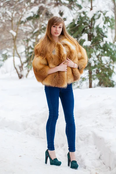 冬公園の背景に贅沢なフォックス毛皮のコートで完全な長さの肖像画金髪の女性 — ストック写真