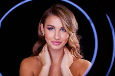 Siyah arka planda uzun sarı saçlı güzel bir mankenin yakın plan portresi.