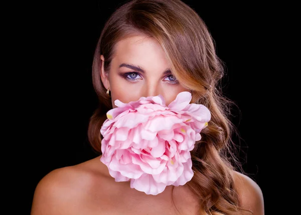 Flower beauty. Close-up portrait of beautiful model with long blond hair on black background