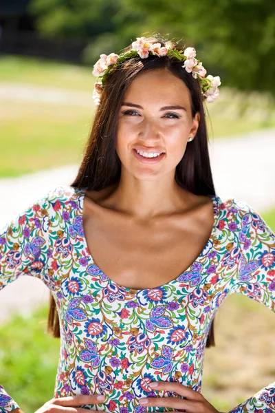 夏の公園の緑に対して カラフルなドレスで美しい若い女性 — ストック写真