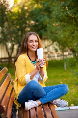 mutlu genç esmer bir bankta oturan