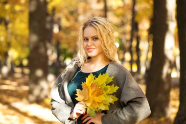 Sonbahar sokak bir arka plan üzerinde gri paltolu bir genç güzel sarışın kadın portresi