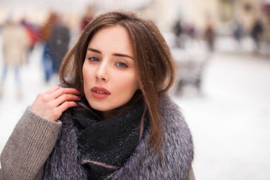 Üzerinde kırmızı bir kare Moskova Merkezi bir kürk yakalı gri paltolu bir genç esmer kadın portresi