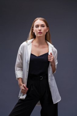 Mutlu sarışın model. İzole gri arka plan üzerinde beyaz gömlekli güzel genç kadın portresi