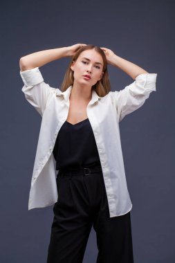 Mutlu sarışın model. İzole gri arka plan üzerinde beyaz gömlekli güzel genç kadın portresi