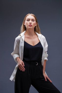 Mutlu sarışın model. İzole gri arka plan üzerinde beyaz gömlekli güzel genç kadın portresi