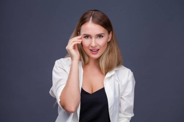 Mutlu sarışın model. İzole gri arka plan üzerinde beyaz gömlekli güzel genç kadın portresi