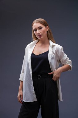 Mutlu sarışın model. İzole gri arka plan üzerinde beyaz gömlekli güzel genç kadın portresi
