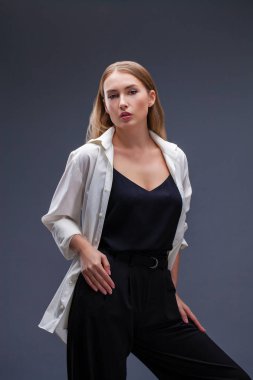 Mutlu sarışın model. İzole gri arka plan üzerinde beyaz gömlekli güzel genç kadın portresi