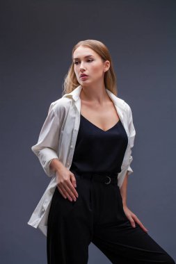 Mutlu sarışın model. İzole gri arka plan üzerinde beyaz gömlekli güzel genç kadın portresi
