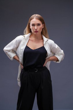 Mutlu sarışın model. İzole gri arka plan üzerinde beyaz gömlekli güzel genç kadın portresi