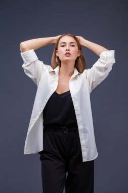 Mutlu sarışın model. İzole gri arka plan üzerinde beyaz gömlekli güzel genç kadın portresi
