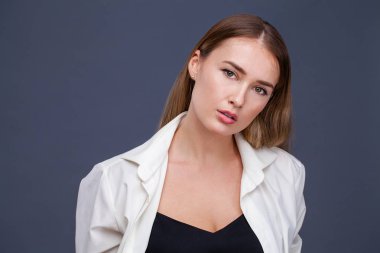 Mutlu sarışın model. İzole gri arka plan üzerinde beyaz gömlekli güzel genç kadın portresi