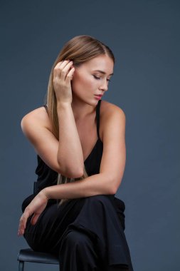 İçinde siyah, gri arka plan üzerinde izole stüdyo mutlu güzel sarışın kadın