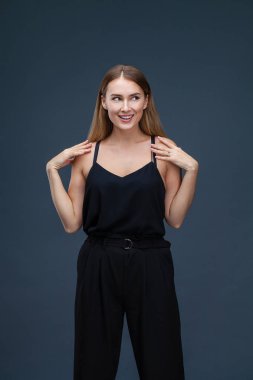İçinde siyah, gri arka plan üzerinde izole stüdyo mutlu güzel sarışın kadın