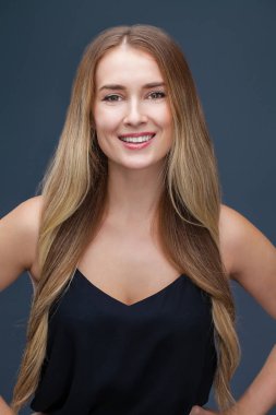 İçinde siyah, gri arka plan üzerinde izole stüdyo mutlu güzel sarışın kadın