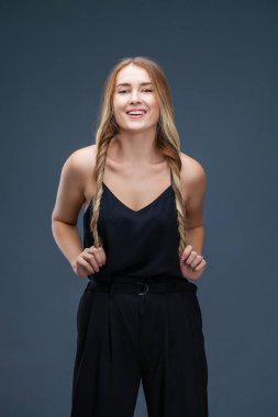 İçinde siyah, gri arka plan üzerinde izole stüdyo mutlu güzel sarışın kadın