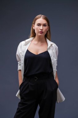 Mutlu sarışın model. İzole gri arka plan üzerinde beyaz gömlekli güzel genç kadın portresi