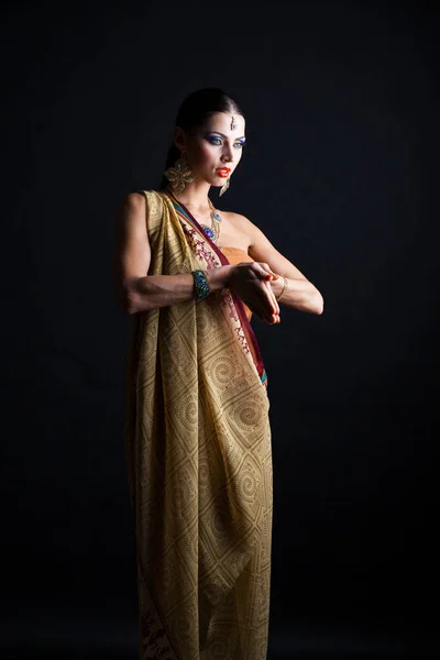 暗いスタジオの背景に茶色のインド民族衣装サリーで白人ブルネットの女性 — ストック写真
