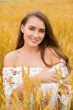 Altın buğday alan, yaz açık havada bir arka plan üzerinde genç seksi bir sarışın kadın portresi
