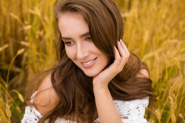 Retrato de una joven sobre un fondo de campo de trigo dorado —  Fotos de Stock