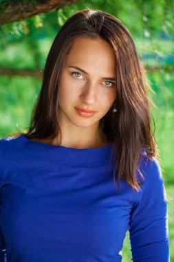 Portre yakın çekim yaz park açık havada mavi elbiseli Genç güzel esmer kadının