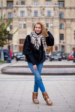 Vizon kış kürk ceket ve mavi kot pantolon, sonbahar sokak açık havada tam uzunlukta genç sarışın kadın portresi