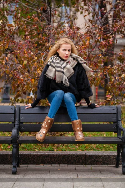 ミンクの毛皮コート通り秋に屋外 ベンチに座っての完全な長さの若い ブロンドの女性の肖像画 — ストック写真