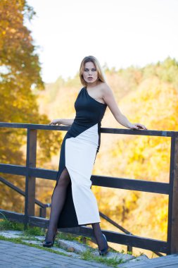 Tam vücut, Sonbahar Park uzun siyah elbise genç güzel sarışın kadın