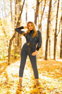 Tam sonbahar park mavi kot tulum şık genç sarışın kadın portresi