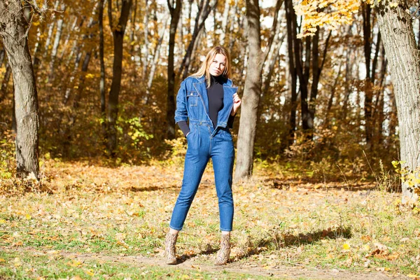 秋天公园穿着蓝色粗斜纹棉布的时尚年轻金发女子的全画像 — 图库照片