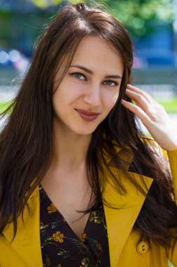 Yakın çekim portre sarı ceketli genç güzel esmer açık havada sokak bahar